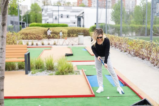 Playing Adventure Golf, downhill shot, ball, club and hole. High quality photo