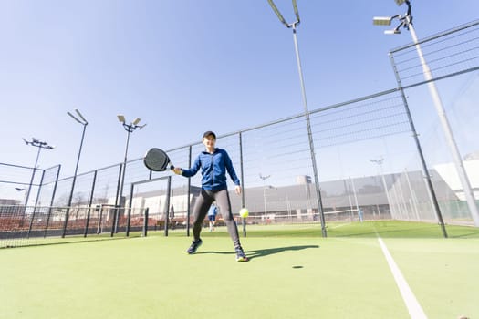 One woman with racquet and ball behind the net in paddle tennis court ready for training. High quality photo