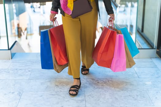 Unrecognizable elegant woman with shopping bags in the mall before Christmas. Holiday shopping sale. High quality photo