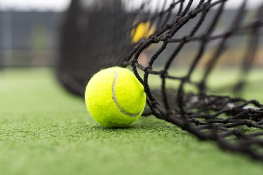 Tennis Ball on the Court against the Court Net. High quality photo