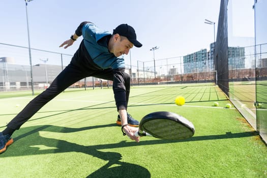 Man playing padel in a green grass padel court indoor behind the net. High quality photo