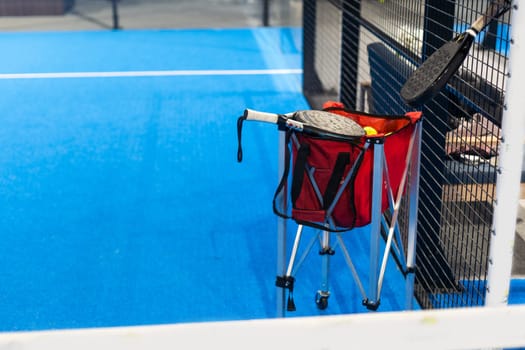 Paddle tennis: Paddel racket and ball in front of an outdoor court. High quality photo