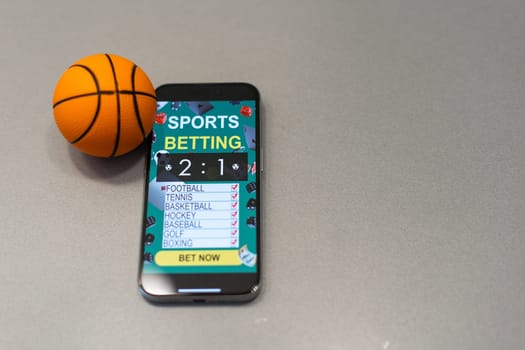 smartphone with application for sport bets and a basketball ball, concept of online bets.
