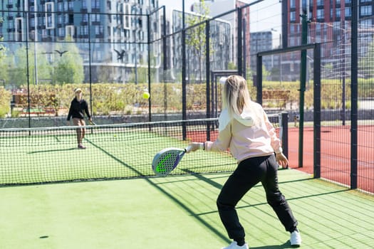 mother and daughter playing padel outdoor. High quality photo