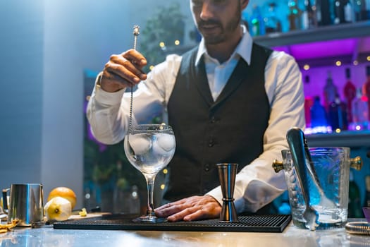 Professional expert barman making cocktail in the counter bar at party in nightclub. Nightlife concept. High quality photo