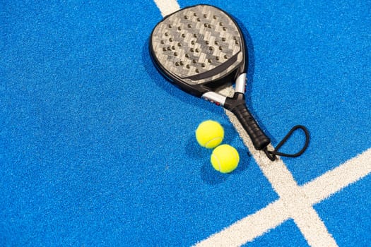 paddle tennis racket and balls on the blue paddle court. High quality photo