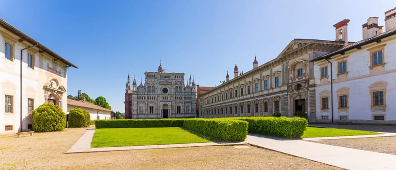 Certosa di Pavia monastery, historical monumental complex that includes a monastery and a sanctuary. green court and a church.The Ducale Palace on the right,Pavia,Italy.