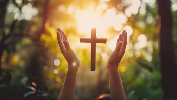 Hands holding a cross in the forest. Christian worship concept.