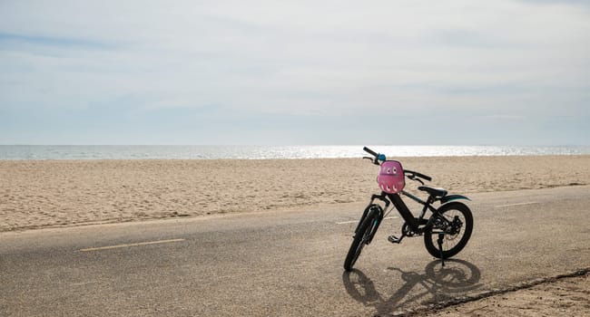 Seascape serenity, A child bicycle rests peacefully on the sandy beach creating a perfect image of leisurely tourism day in North California sun during the summer season. bike in summertime vacations