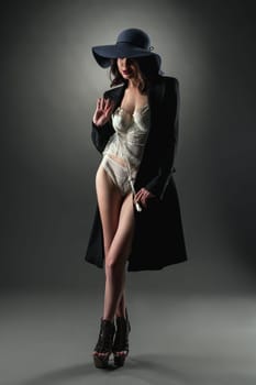 Image of model dressed in sexy lace lingerie, coat and hat