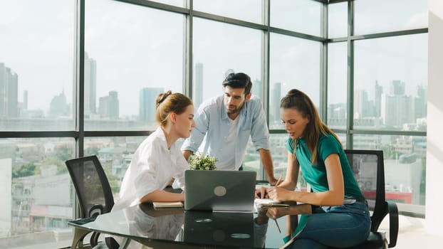 Group of skilled businesspeople sharing idea about marketing plan. Professional business team working together, discussing, talking at meeting table with laptop, document with cityscape. Tracery