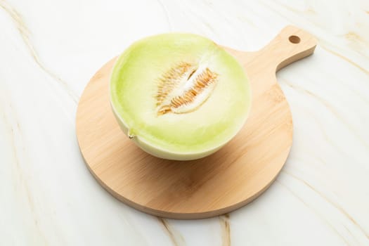 Cut Organic Honeydew Melon On Wooden Cutting Board on Granite Table, Cucumis Melo Inodorus Group. Ripe Nutritious Summer Juicy Fruit. Horizontal Plane. Harvesting, Top View. High quality photo
