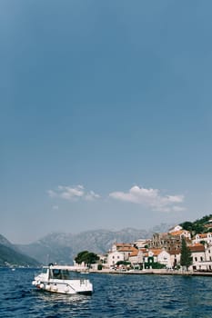 Excursion motor boat is moored near the shore of Perast. Montenegro. High quality photo