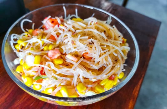 Dish of glass noodles with corn onions and tomatoes in Zicatela Puerto Escondido Oaxaca Mexico.