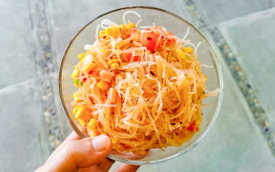 Dish of glass noodles with corn onions and tomatoes in Zicatela Puerto Escondido Oaxaca Mexico.