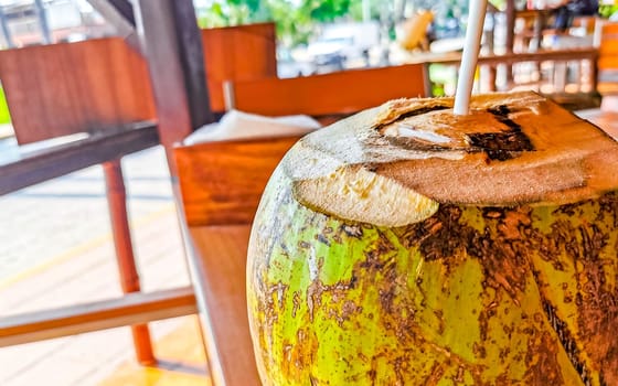 Tropical coconut with straw on the table in Zicatela Puerto Escondido Oaxaca Mexico.