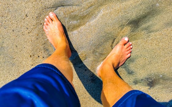 Walking barefoot on the beach sand by the water in Zicatela Puerto Escondido Oaxaca Mexico.