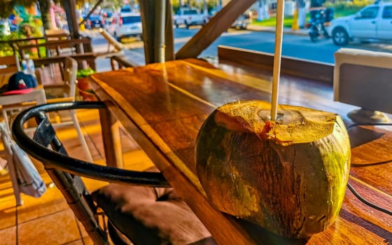 Tropical coconut with straw on the table in Zicatela Puerto Escondido Oaxaca Mexico.