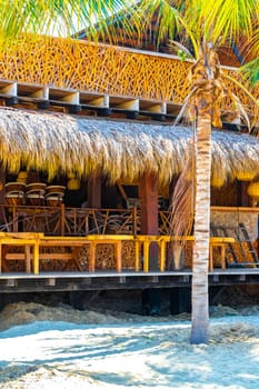 Puerto Escondido Oaxaca Mexico 13. November 2022 Parasols umbrellas sun loungers palms people bars restaurants and waves at the tropical mexican beach in Zicatela Puerto Escondido Oaxaca Mexico.