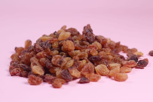 brown raisin on pink background, close up