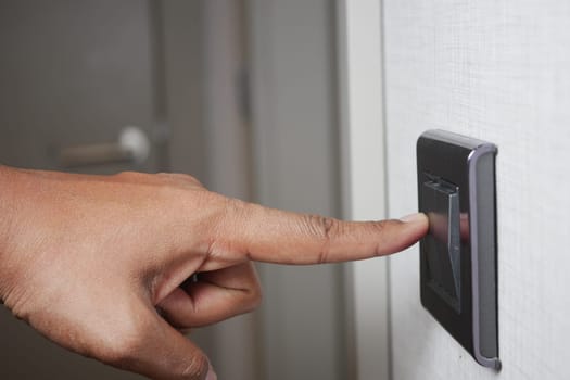 A finger turning on lighting switch