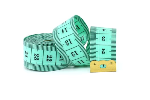 Spirals of green tape measure create a visual impression of motion, isolated white background