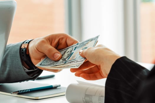 Businessman hand sending money to another business person. Transaction, payment, salary and banking concept. uds