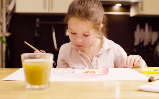 Young artist painting on paper with watercolors using a brush