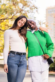 multiracial couple of two young women smiling happy looking at camera, concept of friendship and happiness