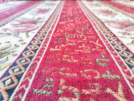 A tablecloth on the table or a carpet on the floor. Background, texture. Detailed texture of a patterned fabric surface