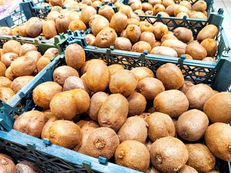 Fresh Kiwi Fruit Displayed for Sale at Market Stand. A selection of ripe kiwis in crates at a local market