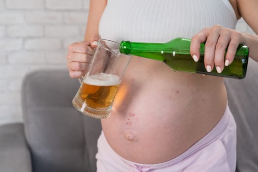Faceless pregnant woman pouring beer into a glass
