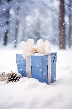 Christmas holiday gift and present, gift box in the snow in snowfall winter countryside nature for boxing day, holidays shopping sale idea