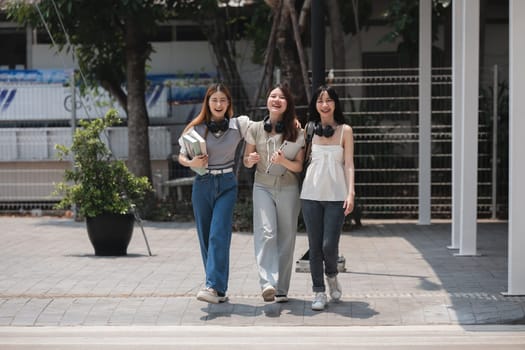 Group of happy students walking along the corridor at college.