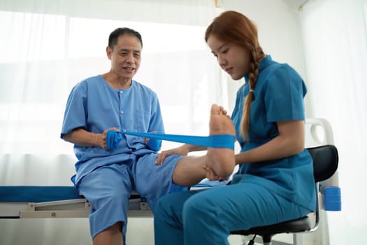 a woman in a blue uniform helps a man in a hospital bed.