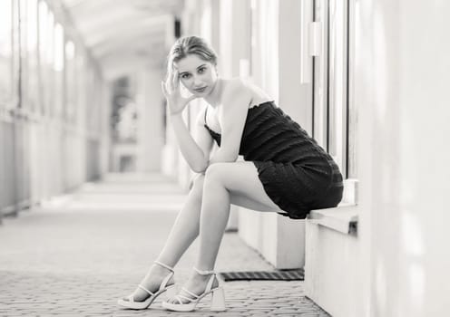 Young Girl Poses In Fashion Style On Street In Dress In Black And White Photo