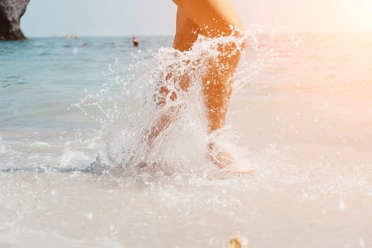 Sea beach travel - woman walking on sand beach leaving footprints in the white sand. Female legs walking along the seaside barefoot, close-up of the tanned legs of a girl coming out of the water