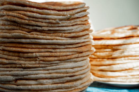 Flatbread lavash, chapati, naan, heap of tortilla on a blue background Homemade flatbread stacked