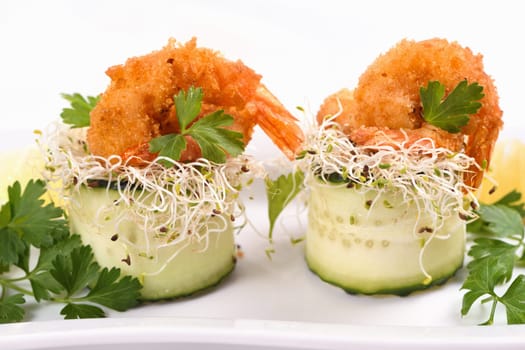 Cucumber appetizer with fried breaded shrimp on a bed of microgreens