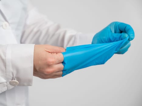 Doctor takes off latex gloves on a white background