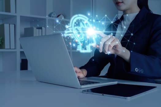 A woman is using a laptop with a blue screen that has a head on it