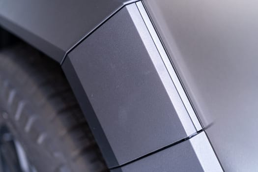 Denver, Colorado, USA-May 5, 2024-This image captures a close-up view of the Tesla Cybertruck, highlighting the intricate design and angular lines of its exterior. The focus on the edge of the panel and the textured surface showcases the unique aesthetic of Tesla innovative electric truck.