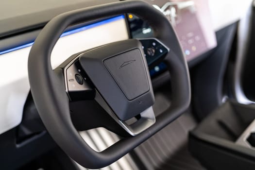 Denver, Colorado, USA-May 5, 2024-This image features a detailed close-up of the unique, minimalist steering wheel design of a Tesla Cybertruck, highlighting its sleek controls and futuristic aesthetic typical of Tesla innovative approach to vehicle design.