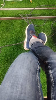 legs of a man in jeans and sneakers. High quality photo