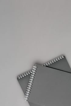 Spiral notebook with black paper sheets on gray isolated background. Top view close up.