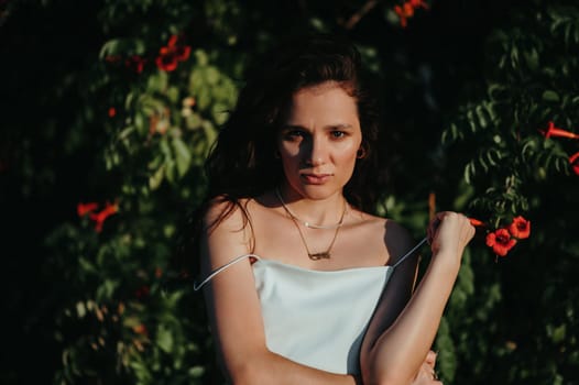 portrait of a sexy Caucasian young girl at the flowering trees in the park in summer