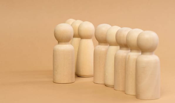 A row of wooden figures and one standing in front. Recruitment concept, talented employee