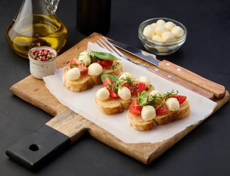 Round mozzarella, cherry tomatoes and microgreens on a piece of white bread, a healthy sandwich	