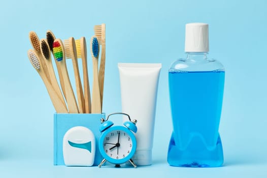 Mouthwash and toothpaste tube blue background, morning routine for oral hygiene