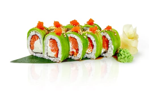 Delicious green sushi roll with salmon, cream cheese and tobiko wrapped in avocado slices drizzled with unagi sauce, traditionally served with gari and wasabi on bamboo leaf, isolated on white